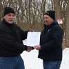 Habitat volunteer Paul Glaser (left) receives the deed to property located in Filer Township from Jacob Bialik, Morton Salt Manistee facility manager. The property had gone unused by Morton Salt for decades. 