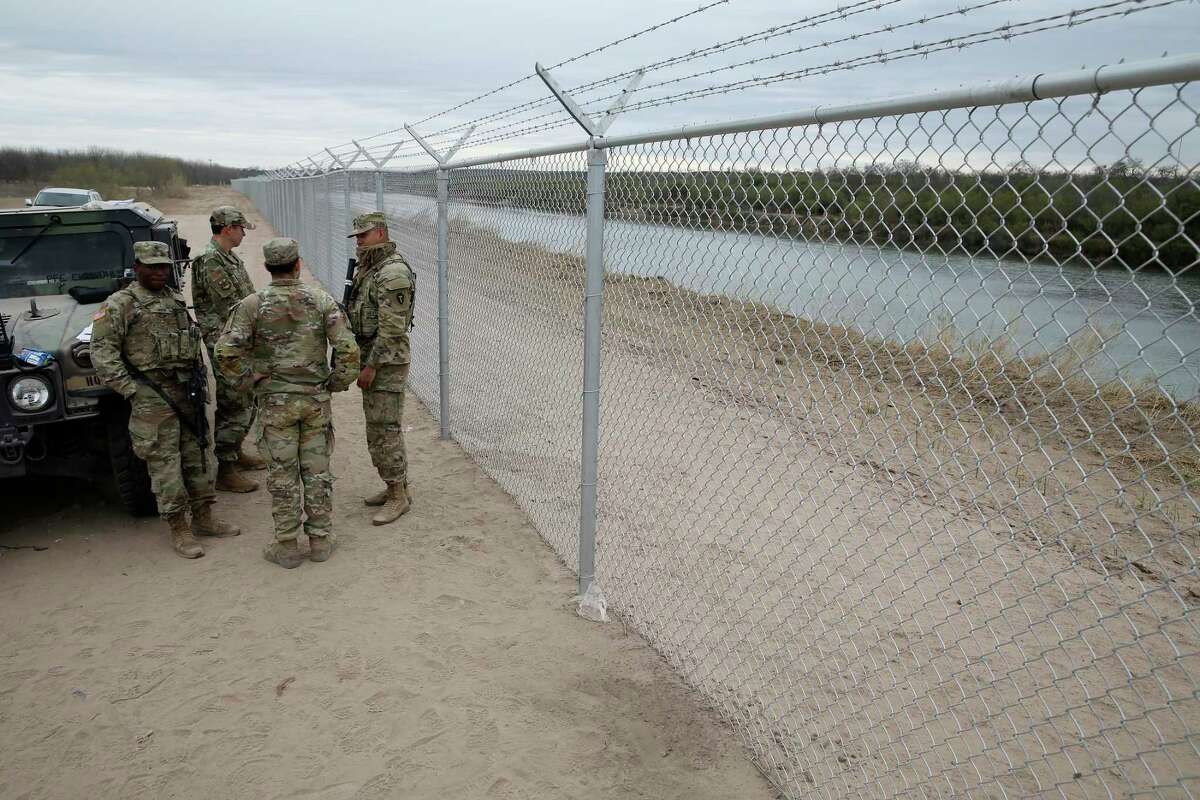 Texas National Guardsmen keep watch by the Abbott fence along the Rio Grande south of Eagle Pass, Texas, Tuesday, Jan. 11, 2022.