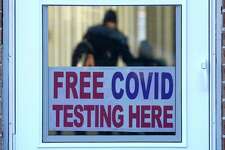 A sign about COVID test is displayed at a testing site as people are seen inside for testing in Morton Grove, Ill., Sunday, Jan. 9, 2022. Hospitalizations of U.S. children under 5 with COVID-19 soared in recent weeks to their highest level since the pandemic began, according to government data released Friday on the only age group not yet eligible for the vaccine. (AP Photo/Nam Y. Huh)