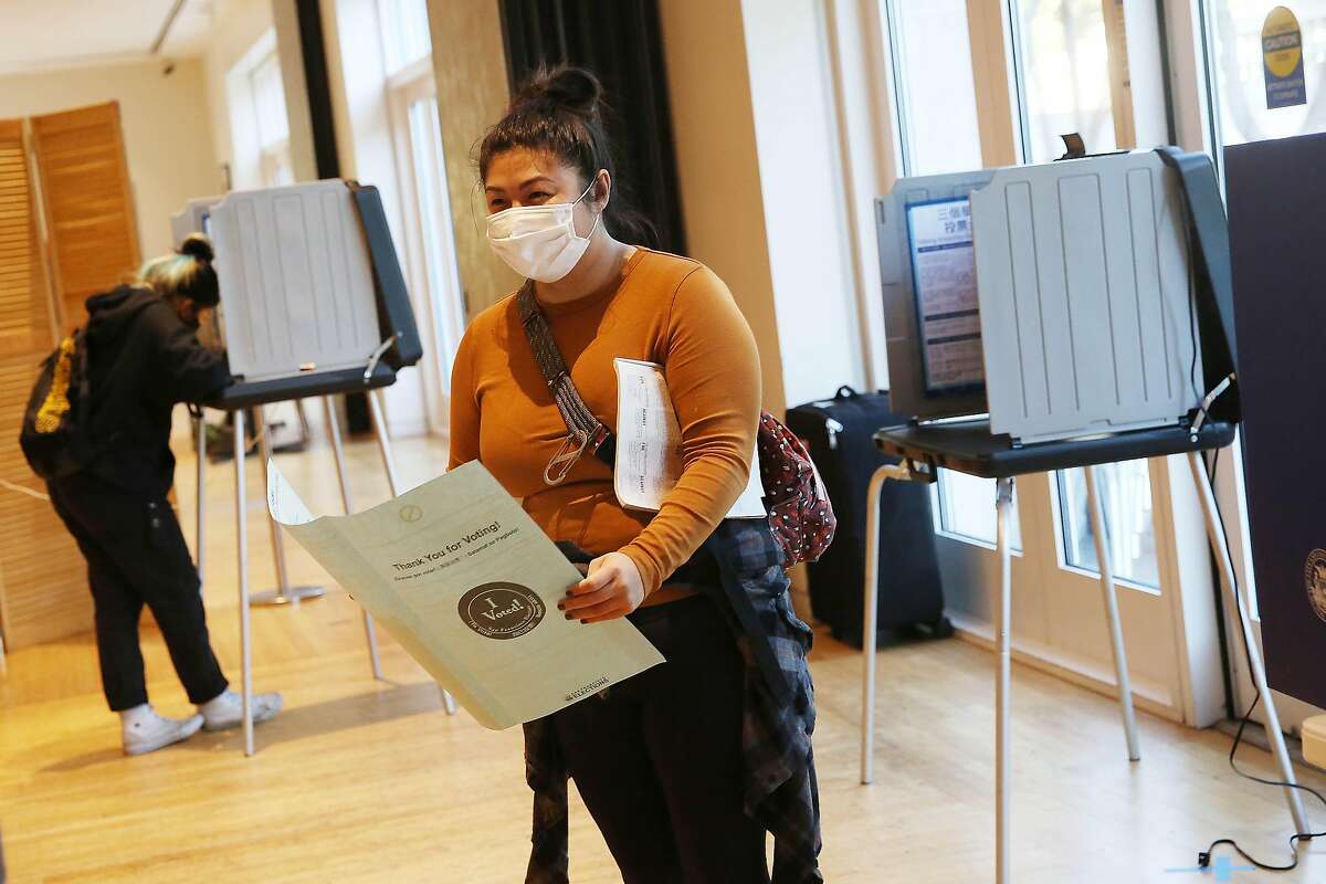 Amber Almanzar of San Francisco smiles as she leaves a voting booth while carrying her ballot to a counter while voting at the polling place at the Legion of Honor on Tuesday, November 3, 2020 in San Francisco, Calif.