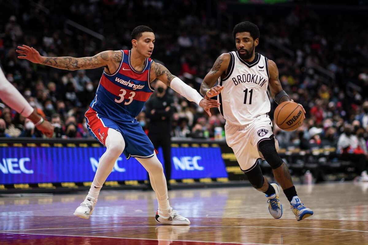 WASHINGTON, DC - JANUARY 19: Kyrie Irving #11 of the Brooklyn Nets goes to the basket against Kyle Kuzma #33 of the Washington Wizards during the second half at Capital One Arena on January 19, 2022 in Washington, DC. NOTE TO USER: User expressly acknowledges and agrees that, by downloading and or using this photograph, User is consenting to the terms and conditions of the Getty Images License Agreement. (Photo by Scott Taetsch/Getty Images)