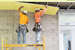 Men installing insulation.