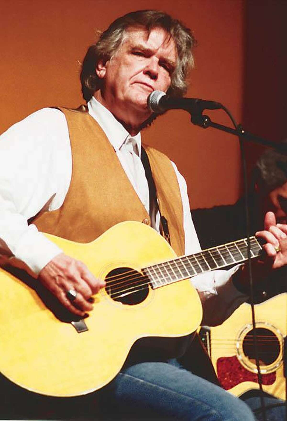 Texas singer and songwriter Guy Clark strums his guitar and entertains the sold-out crowd at the Crighton Theatre in Conroe in 2000. Clark and fellow entertainer Terry Allen appeared in the Sounds of Texas Music Series.