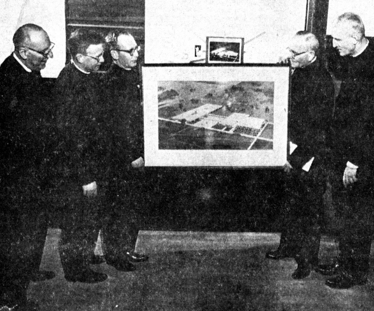 The pastors of the five Catholic parishes in the area announced the beginning of the Manistee Catholic Central high school campaign at all masses yesterday. Shown looking over the architect's sketch of the school are (from left) Rev. Anthony Bourdow, pastor of St. Mary's in Manistee; Rev. Joseph Reitz, pastor of St. Bernard's, Irons; Rev. William Reitz, pastor of St. Joseph's, Onekama; Rev. B.B. Roguszka, pastor of St. Joseph's, Manistee; and Rev. Edward Kubiak, pastor of Guardian Angels in Manistee. The photo was published in the News Advocate on Jan. 22, 1962.