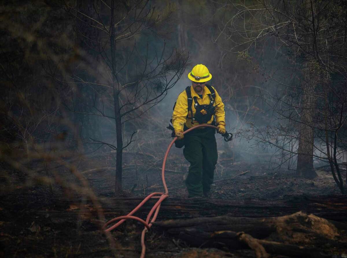 A firefighter continues to work Thursday, Jan. 20, 2022 to extinguish hotspots in the Rolling Pines Fire in Bastrop County. The nearly 800 acre wildfire likely began with a Texas Parks and Wildlife Department prescribed burn in Bastrop State Park that got out of control Tuesday.