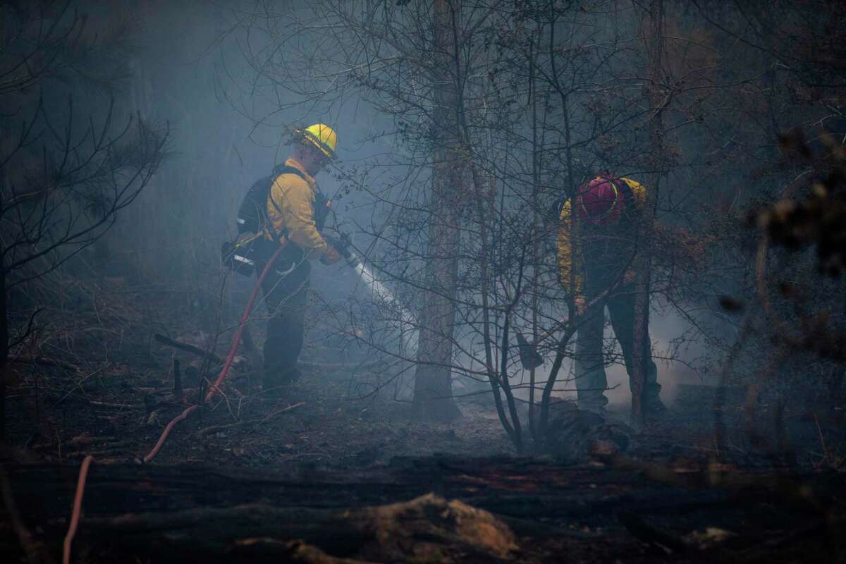 Firefighters continue to work Thursday, Jan. 20, 2022 to extinguish hotspots in the Rolling Pines Fire in Bastrop County. The nearly 800 acre wildfire likely began with a Texas Parks and Wildlife Department prescribed burn in Bastrop State Park that got out of control Tuesday.