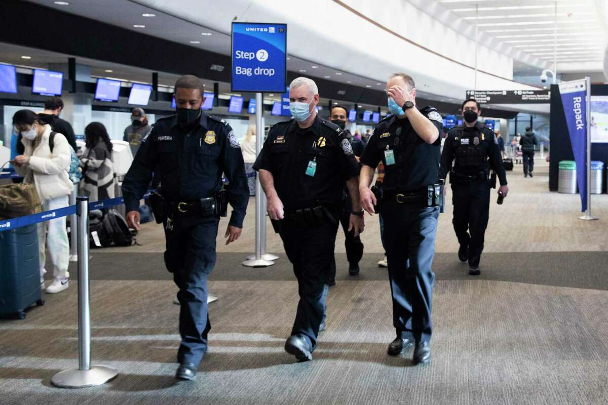 Police officers walk through the domestic terminal at San Francisco International Airport in San Francisco, Calif. After officers shot and killed an allegedly armed individual in front of the BART station entrance inside the International Terminal.