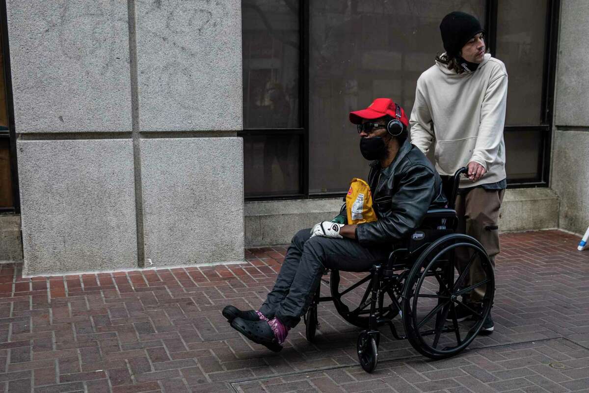 Max Parkinson pushes his friend Willie on a wheelchair after visiting the new Tenderloin Linkage Center before it opened.