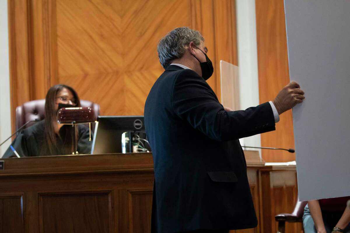 Jamaica Miles attorney Kevin Luibrand, right, shows a photograph of a protest as a piece of evidence to a witness and Judge Francine Vero during Miles’ preliminary hearing in Saratoga Springs City Court on Thursday, Jan. 20, 2022 in Albany, N.Y. Miles is fighting a misdemeanor unlawful imprisonment and disorderly conduct violation.