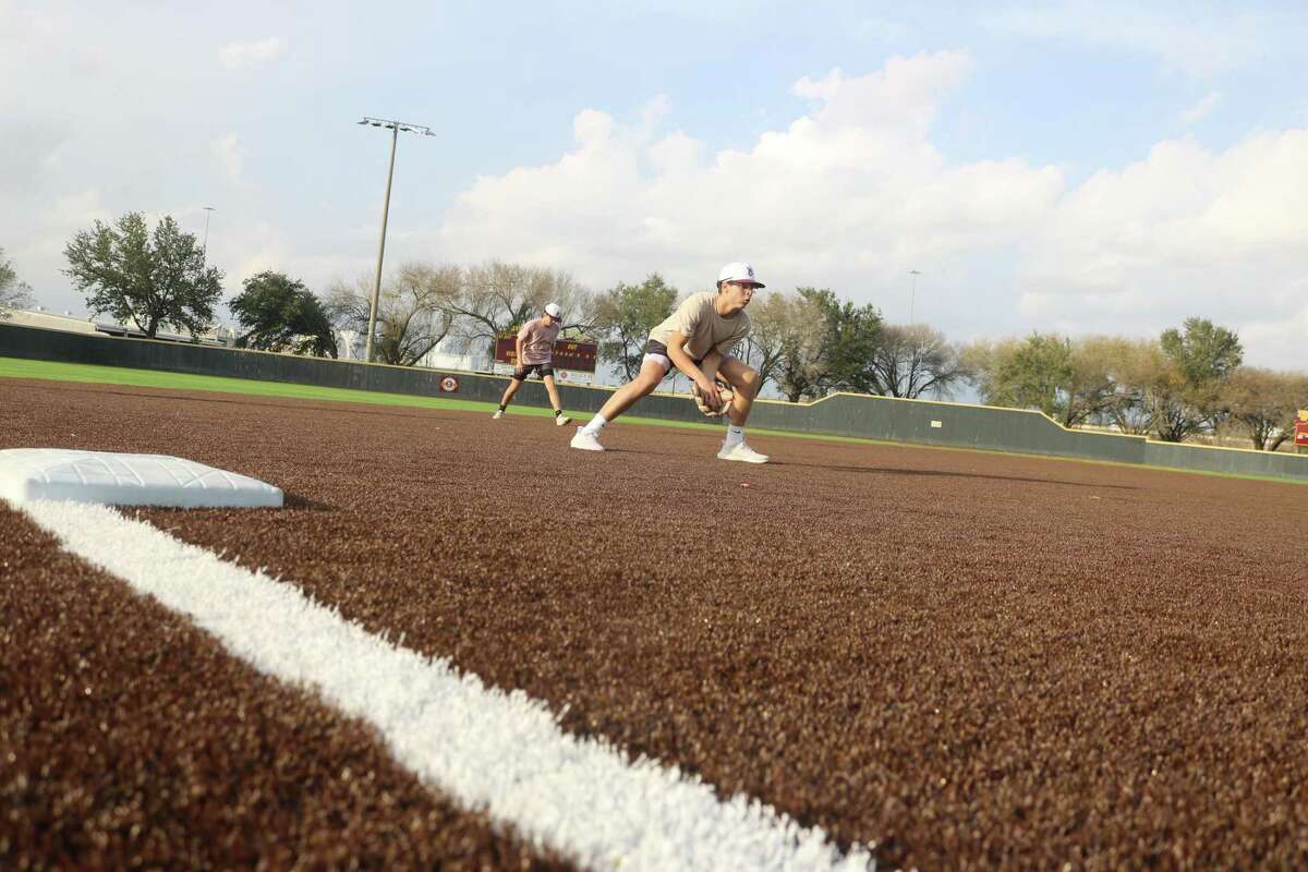 A player gets accustomed to Kethan Field's new artificial surface, fielding a ground ball on the "dirt" portion of the field.