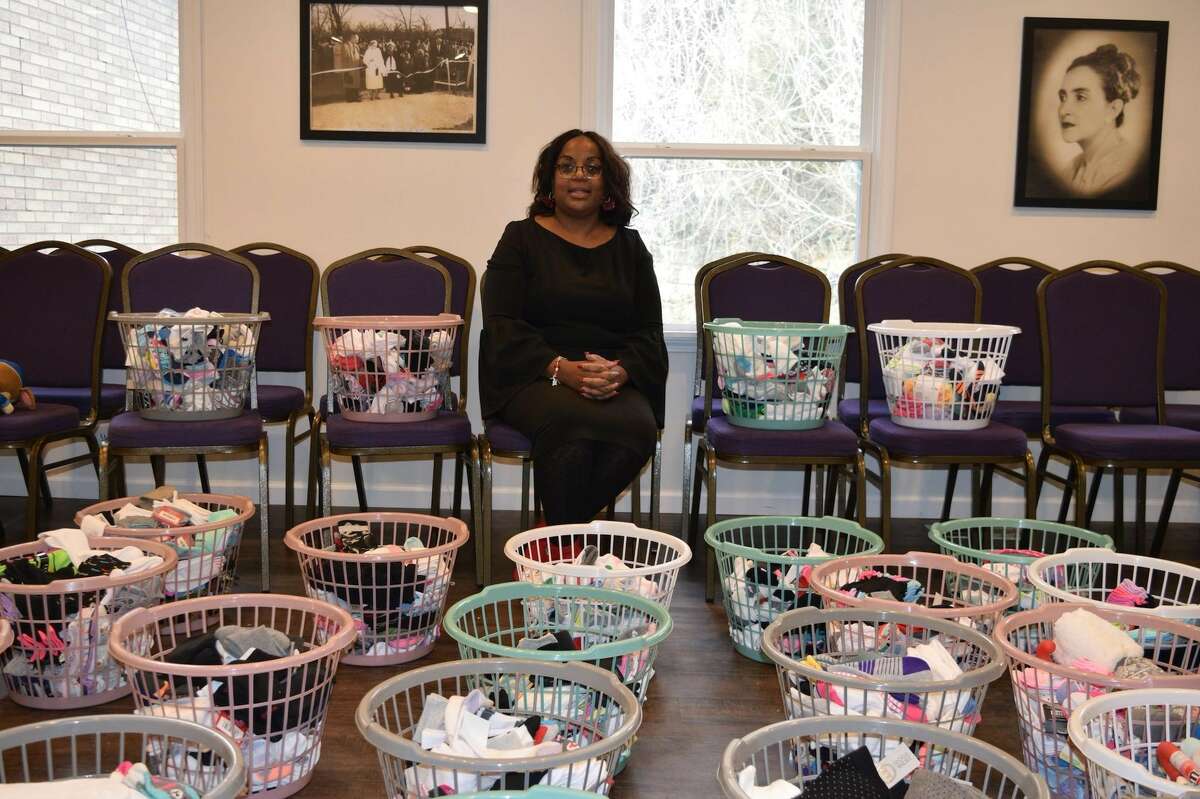 Alton Alderwoman Rosetta Brown sits amid more than 2,000 pairs of socks donated this year to Socks for Tots.