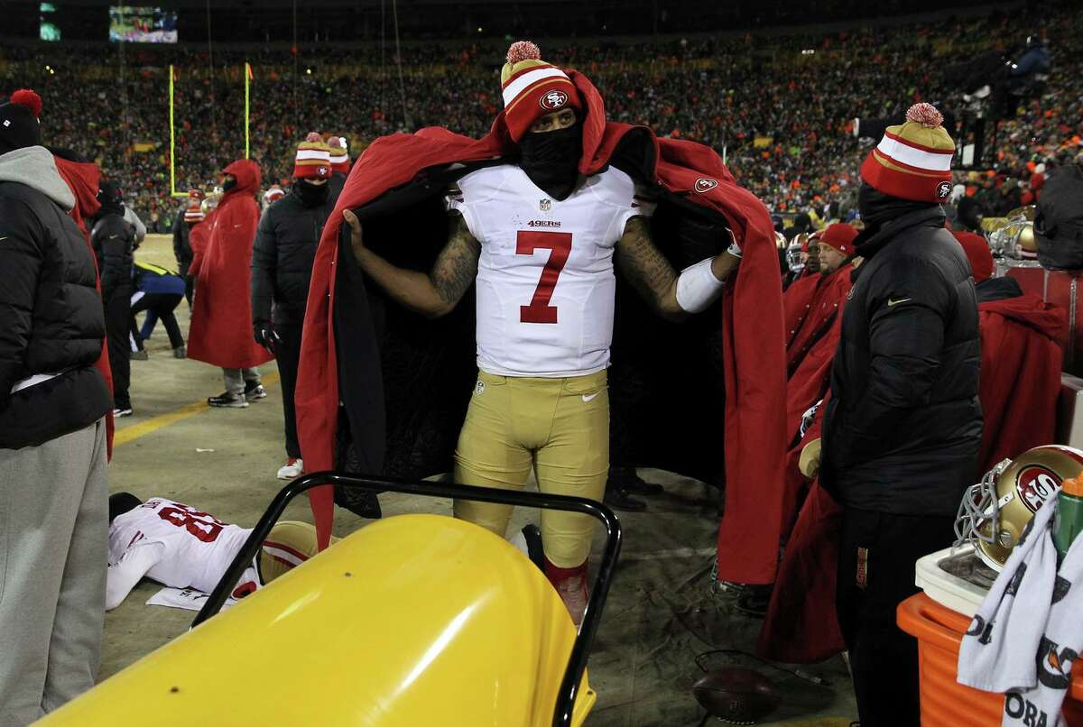 Quarterback Colin Kaepernick of the 49ers warms up on the sideline during an NFC Wild Card game against the Packers at Lambeau Field in 2014.