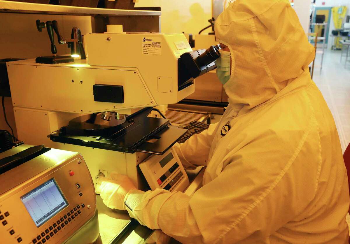 A worker scans a silicon wafer at Tower Semiconductors in Westover Hills, Friday, Jan. 14, 2022. The company produces computer chips that are used in several industries including the automotive and smart phone production.