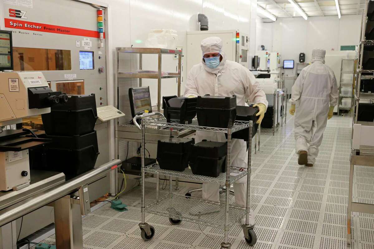 Workers produce computer chips at Tower Semiconductors in Westover Hills, Friday, Jan. 14, 2022. The chips are used in several industries including the automotive and smart phone production.