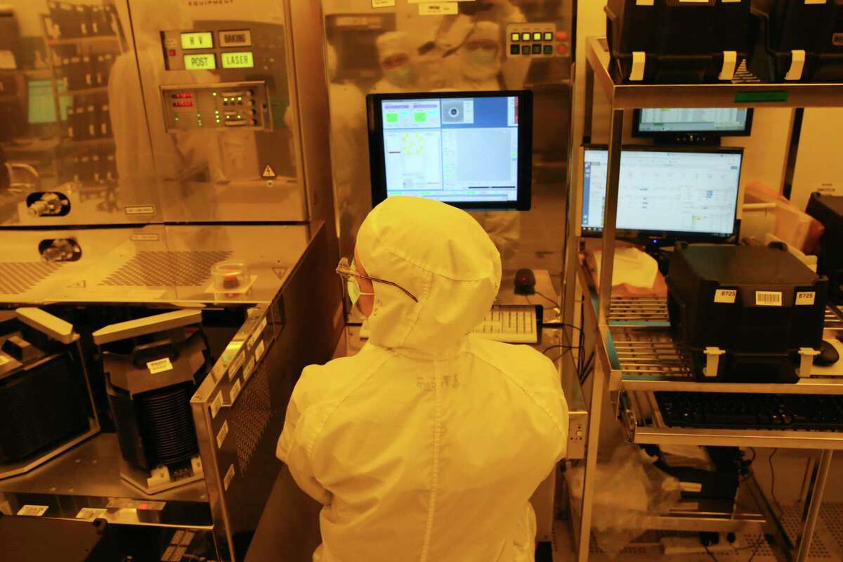 Workers produce computer chips at Tower Semiconductors in Westover Hills, Friday, Jan. 14, 2022. The chips are used in several industries including the automotive and smart phone production.