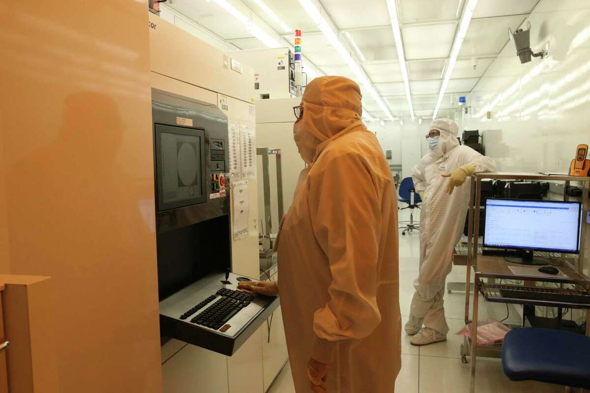 Workers scan silicon wafers for defects at Tower Semiconductors’ fabrication plant in Westover Hills in January. The company produces computer chips that are used in several industries, including automotive and smartphone production.