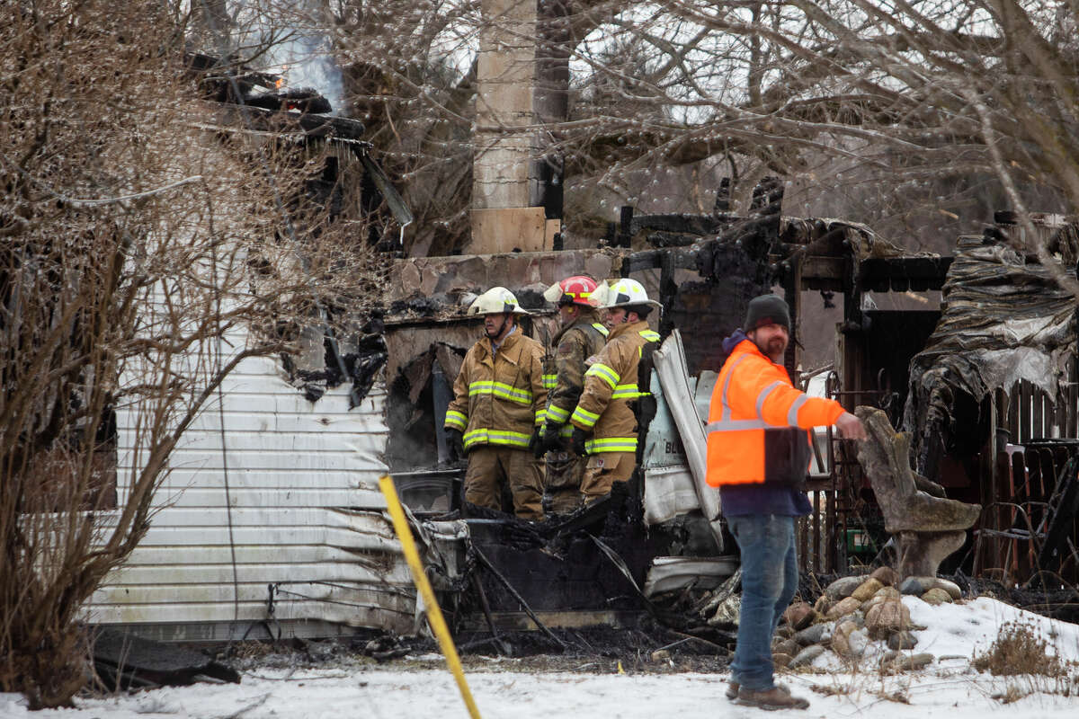 Firefighters from Edenville Township, Beaverton, Billings Township, Hope Township and Jerome Township work to control a blaze Thursday, Jan. 20, 2022 at a home on Flock Road in Edenville Township.