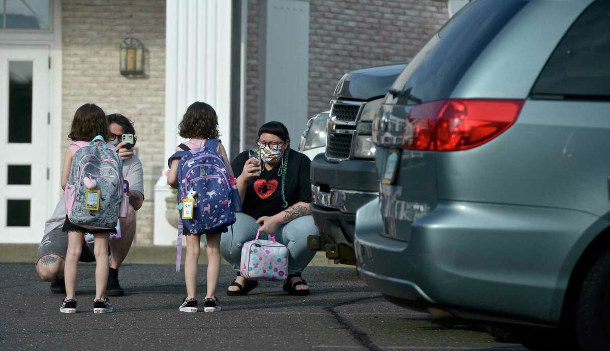 Ian Copland, left, and Megan Tucker, of Danbury, take photographs while dropping off their twin daughters Lilith, left, and Lydia Copland for the first day of kindergarten at the Danbury Primary Center in Brookfield. Monday, August 30, 2021, Brookfield, Conn. Danbury plans to close the school after one year and bring kindergartners back to schools in the Hat City.