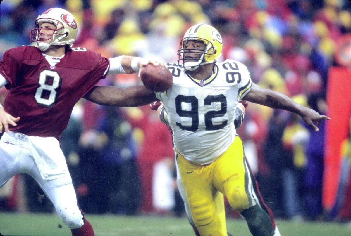 Defensive end Reggie White game action against 49ers quarterback Steve Young during the Green Bay Packers 23-10 win over the San Francisco 49ers at 3Com Park in San Francisco, California on January 11, 1998. (Photo by Allen Kee/Getty Images)
