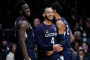 UConn’s Tyrese Martin, center, is congratulated by teammates Tyler Polley, right, and Adama Sanogo after being fouled against Butler in Indianapolis on Thursday.