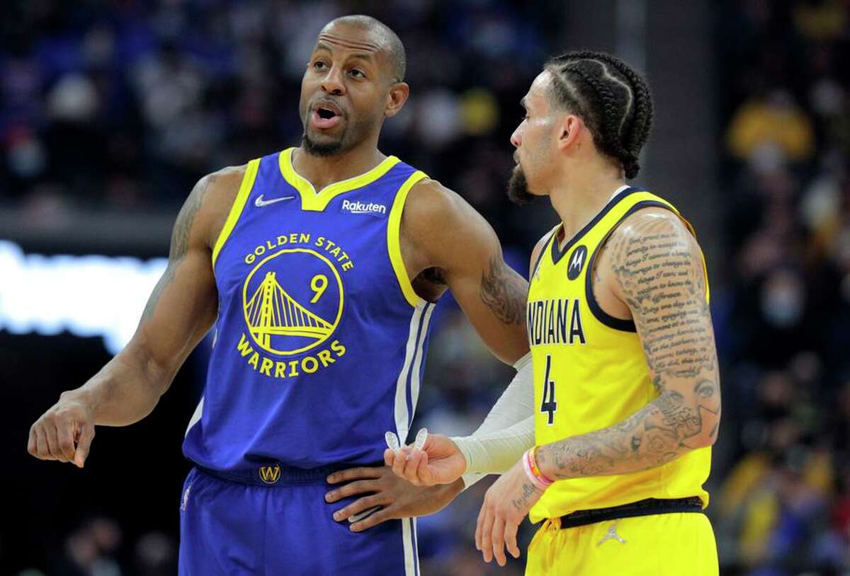 Andre Iguodala (9) talks with Indiana’s Duane Washington Jr. (4) in the first half of the Warriors-Pacers game on Jan. 20. Iguodala will not play in Golden State’s final two games before the All-Star break, though he’s “doing a lot better,” head coach Steve Kerr said.