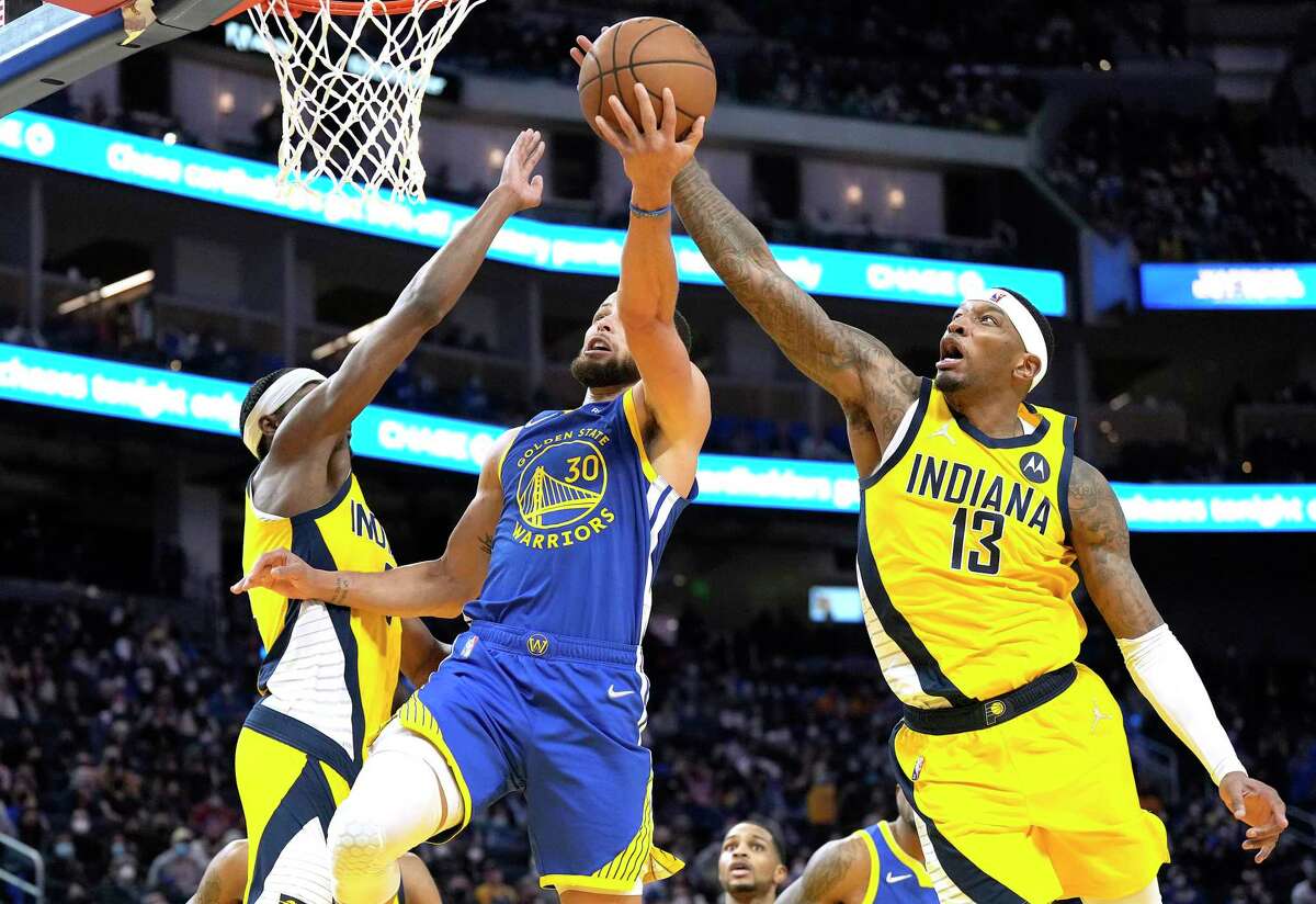 SAN FRANCISCO, CALIFORNIA - JANUARY 20: Torrey Craig #13 of the Indiana Pacers blocks the shot of Stephen Curry #30 of the Golden State Warriors during overtime of an NBA basketball game at Chase Center on January 20, 2022 in San Francisco, California. NOTE TO USER: User expressly acknowledges and agrees that, by downloading and or using this photograph, User is consenting to the terms and conditions of the Getty Images License Agreement. (Photo by Thearon W. Henderson/Getty Images)