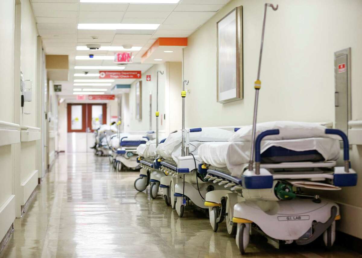 A line of empty beds can be seen on a hallway inside the Emergency Department at Houston Methodist Hospital on Tuesday, Dec. 21, 2021, in Houston.