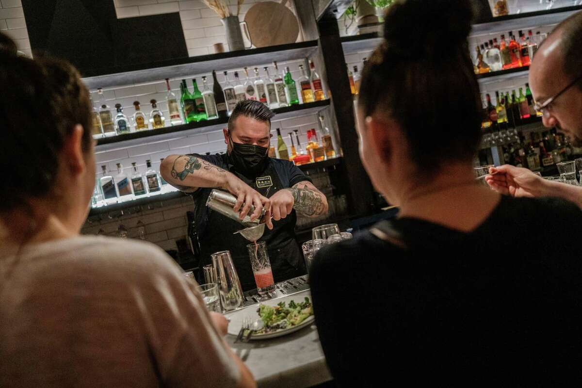 Bartender Becker Vonfelsburg is seen working during dinner service at Fiorella in San Francisco. The restaurant has started looking to hire people with less experience as more and more people are leaving their jobs for different opportunities.