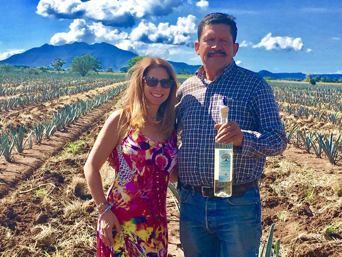 Lisa Elovich stands in the agave field with her master distiller Eladio Montes, whose family owns the farm where One Life Tequila gets its start.