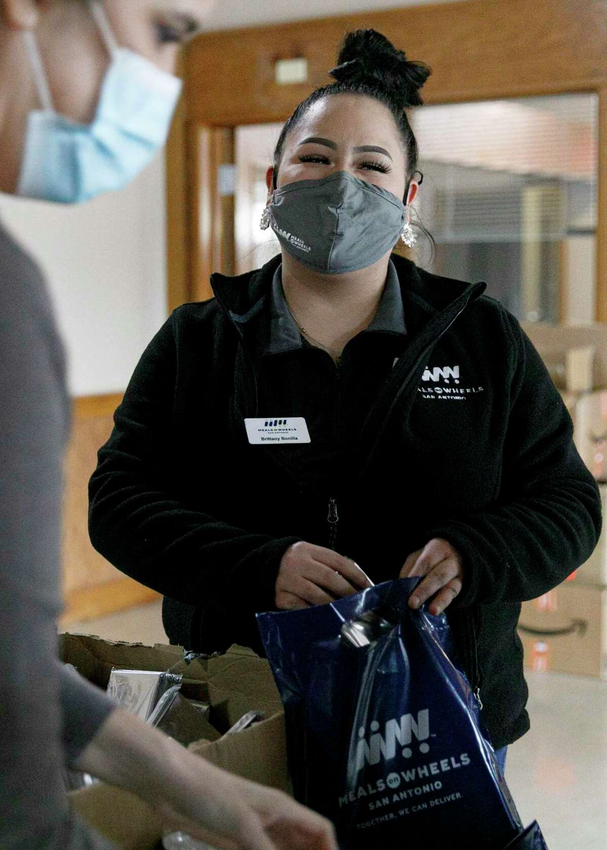 Meals on Wheels employee Brittany Bonilla helps pack up emergency preparedness winter storm kits, which will include emergency blankets and hand warmers, on Friday, Jan. 21, 2022.