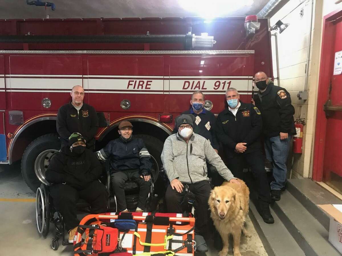 Shelton-based Moving with Hope donated two FAST boards to the Shelton Fire Department. Pictured are, left to right, past Assistant Chief Shaun Wheeler, Nikita Rose, Everett Mosher, Todd Johnston, “Madden,” Moving with Hope founder Thatcher Duni, Deputy Chief Paul Wilson and Lt. Scott Goldin.