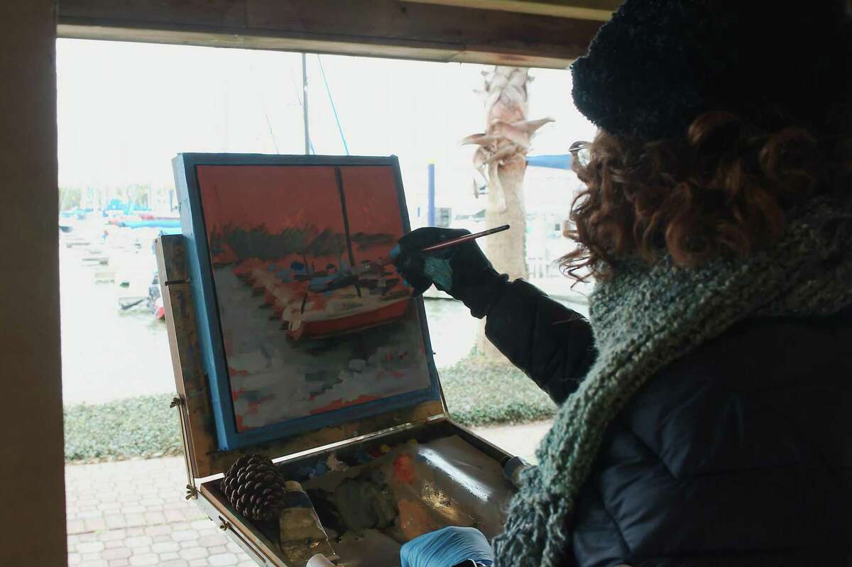 Kathy Hammond paints a scenic view of boats docked at Watergate Yachting Center.