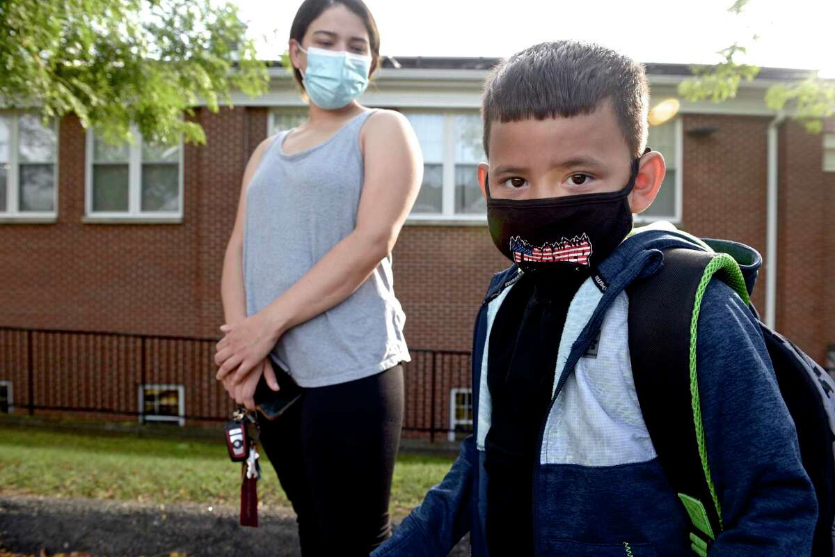 Dinan Mora, 5, of Danbury, waits with his mother Leydi Rosario at the Danbury Primary Center in Brookfield for the first day of kindergarten to begin. Monday, August 30, 2021, Brookfield, Conn. Danbury school board is expected to vote Monday on whether to rescind its mask mandate.