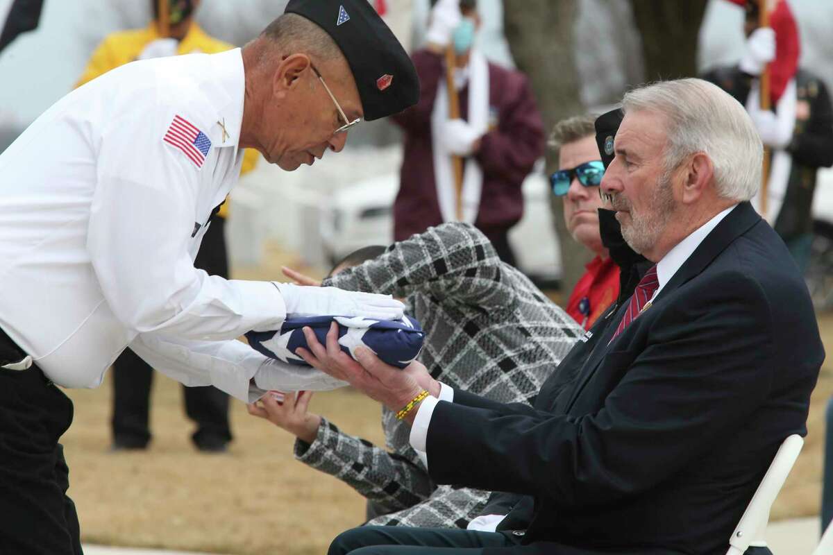 Civilian Aide to the Secretary of the Army Joseph Bray receives the U.S. flag on behalf of the 46 unaccompanied veterans.