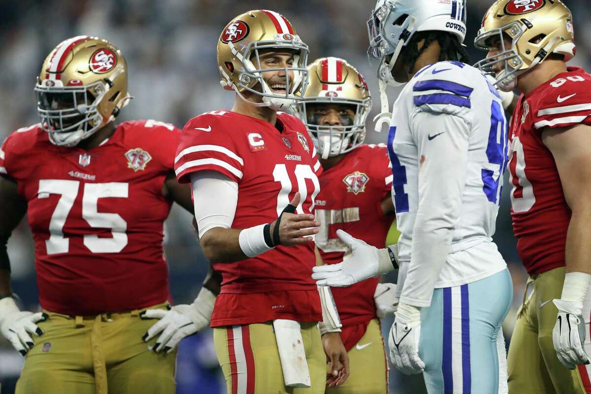 San Francisco 49ers' Jimmy Garoppolo laughs with Dallas Cowboys' Randy Gregory in 3rd quarter of the 49ers’ 23-17 win during at AT&T Stadium in Arlington, Texas, on Sunday, Jan. 16, 2022.