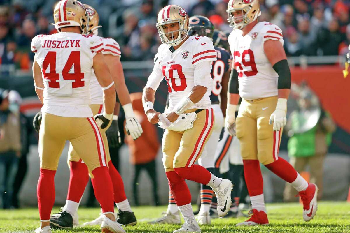 Jimmy Garoppolo of the San Francisco 49ers celebrates his second rushing touchdown of the game in the 49ers 33-22 win over the Bears at Soldier Field in Chicago on Sunday, October 31, 2021.
