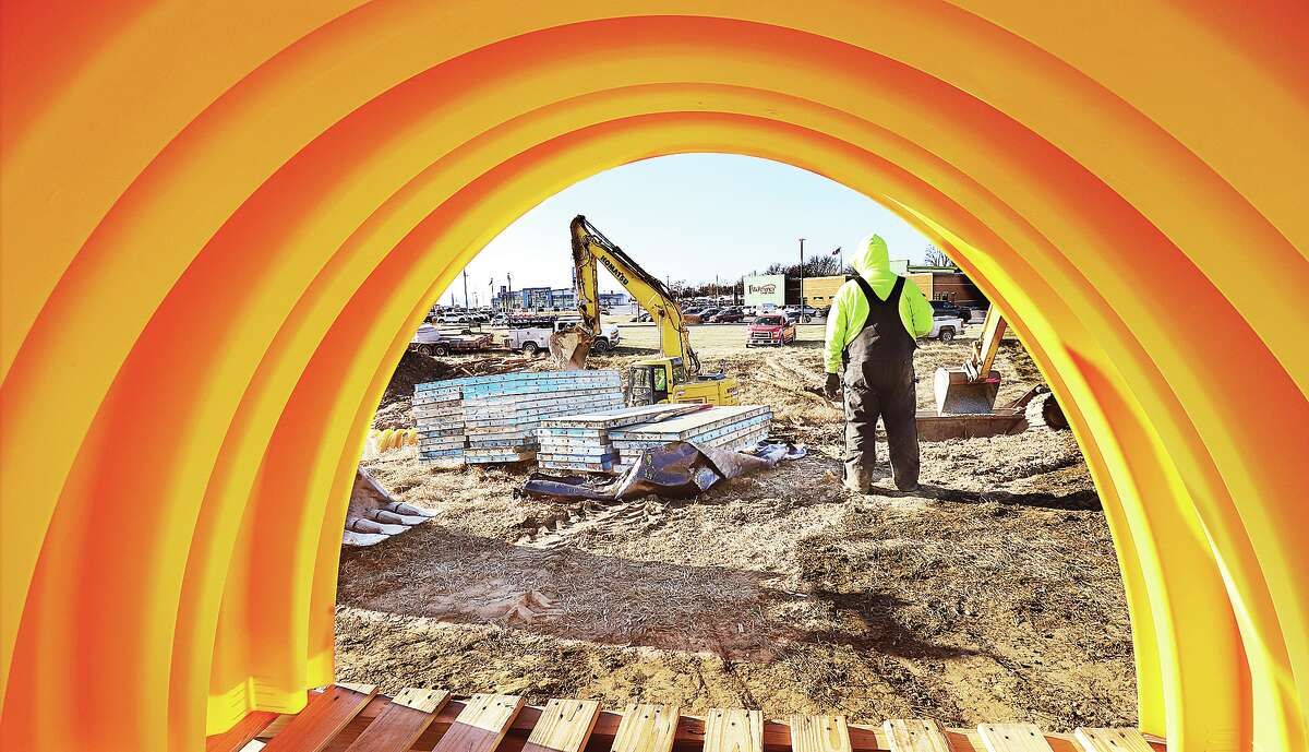 John Badman|The Telegraph A worker is framed by one of dozens of arch shaped plastic sections which will be linked to form a storm water tunnel in the ditch between Illinois 143 and East Rock Road just west of Wesley Drive in Wood River Thursday.