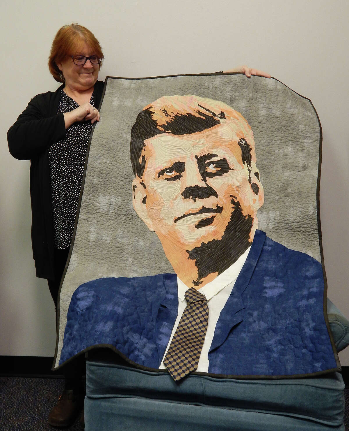 Rosanne Hamilton displays a photo quilt featuring a likeness of John F. Kennedy. The quilt has been accepted into the American Quilter's Society show in March in Branson, Missouri.