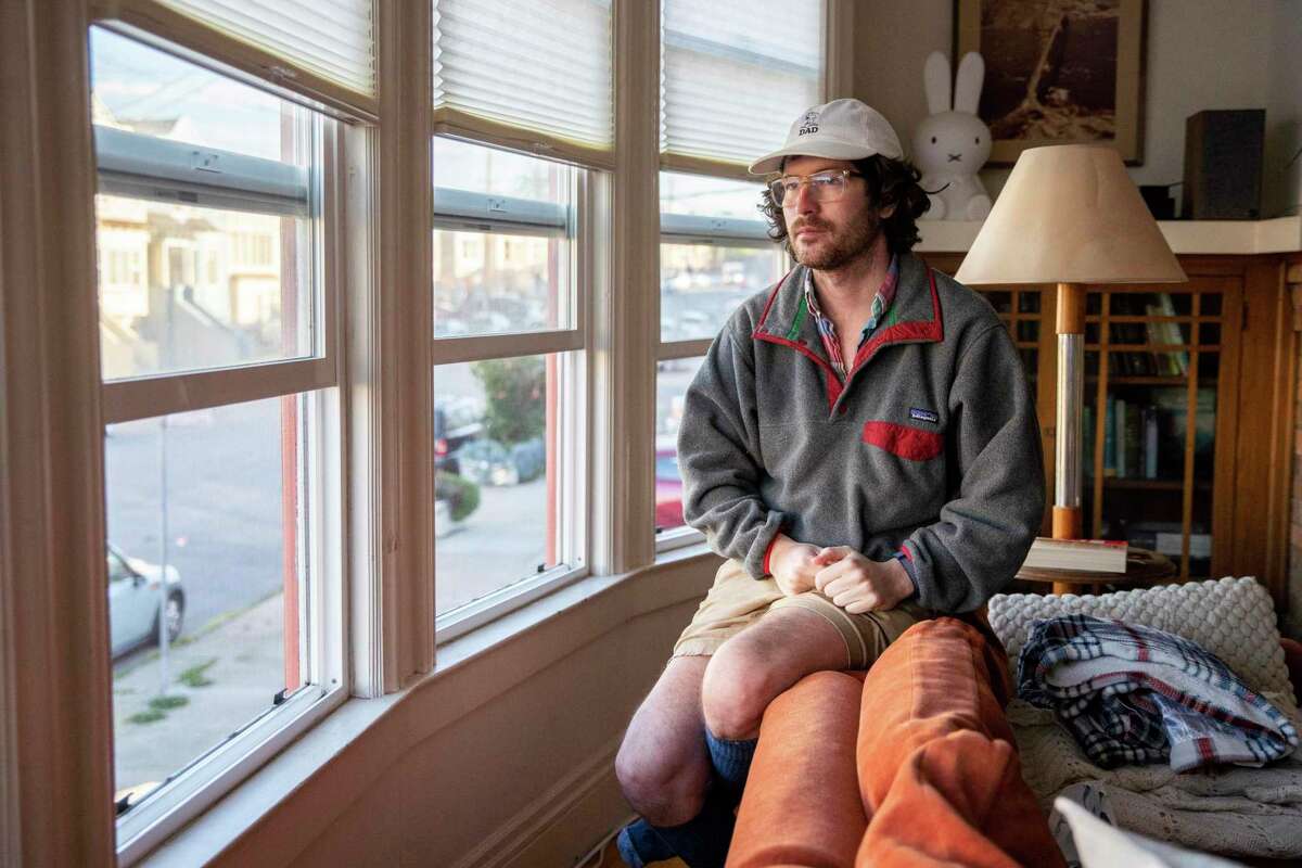 A portrait of Charlie McCone at his home, Thursday, Jan. 20, 2022, in San Francisco. McCone tested positive for the novel coronavirus in March 2020 and has had severe symptoms ever since. He’s on short-term disability from his nonprofit job.