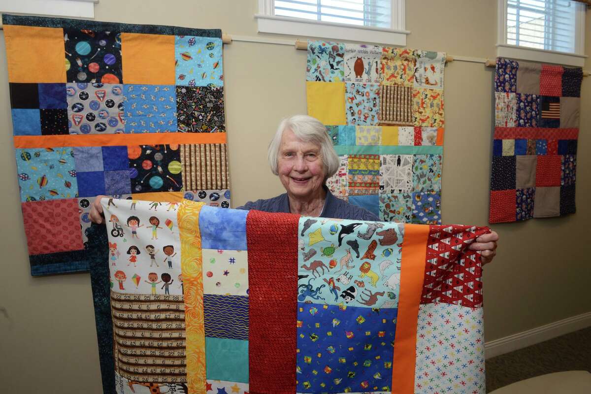 Sturges Ridge of Fairfield resident Cecily Zerega poses with some of her quilts in Fairfield, Conn. Jan. 19, 2022. At 91, Zerega continues to make quilts that she donates to local school children.