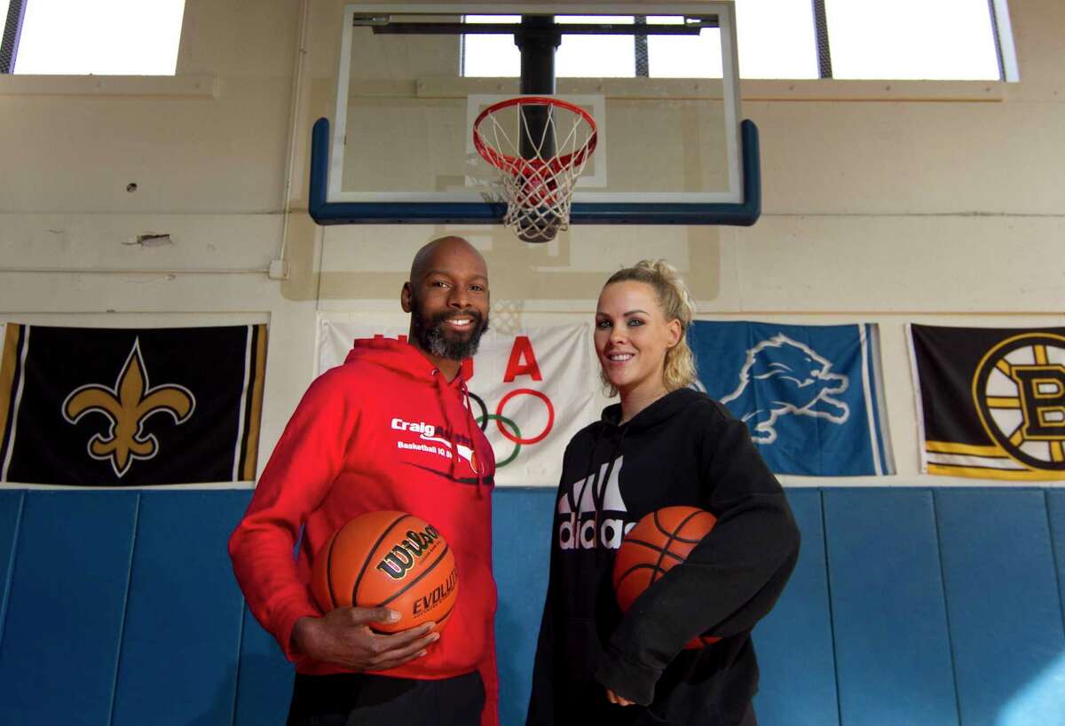 Former UConn and Trinity Catholic basketball star Craig Austrie and his wife Heather pose at their basketball training facility inside BlueStreak Sports Training in Stamford, Conn., on Friday Jan. 14, 2021.