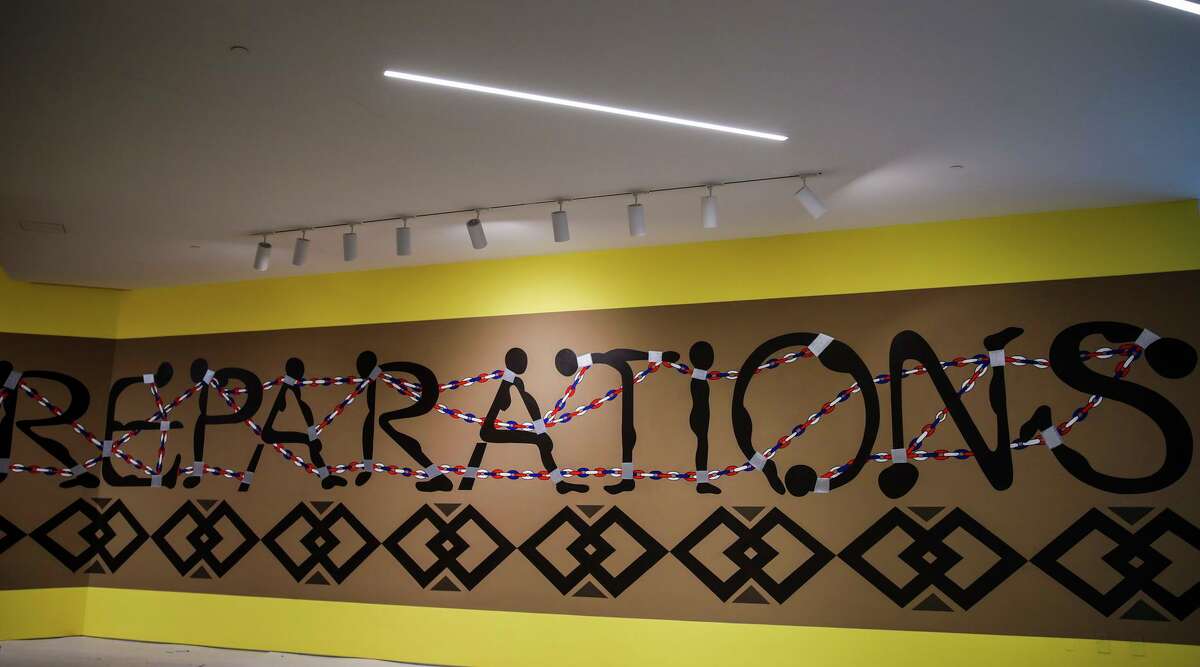 A mural by former Black Panther Emory Douglas called “Reparations” hangs in the San Francisco Museum of Modern Art in 2021. Reparations for descendants of slaves will again be a hot topic in California as the state’s reparations task force begins its second year of studying slavery’s legacy.