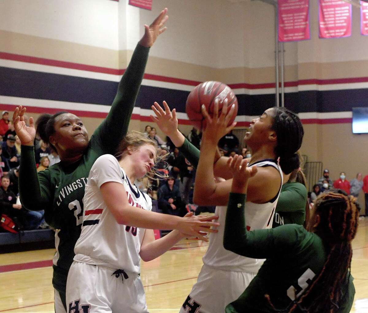 Hardin-Jefferson's Molly Beavers (left) is in the mix with Livingston's Jon'Toyrian McNeal and N'ziya Washinton as Ashlon Jackson tries to put up a shot against Livingston during Friday's home game. Photo made Friday, January 21, 2022 Kim Brent/The Enterprise