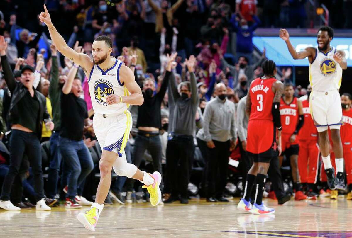 Warriors guard Stephen Curry leads the celebration after hitting the game-winner against the Rockets.