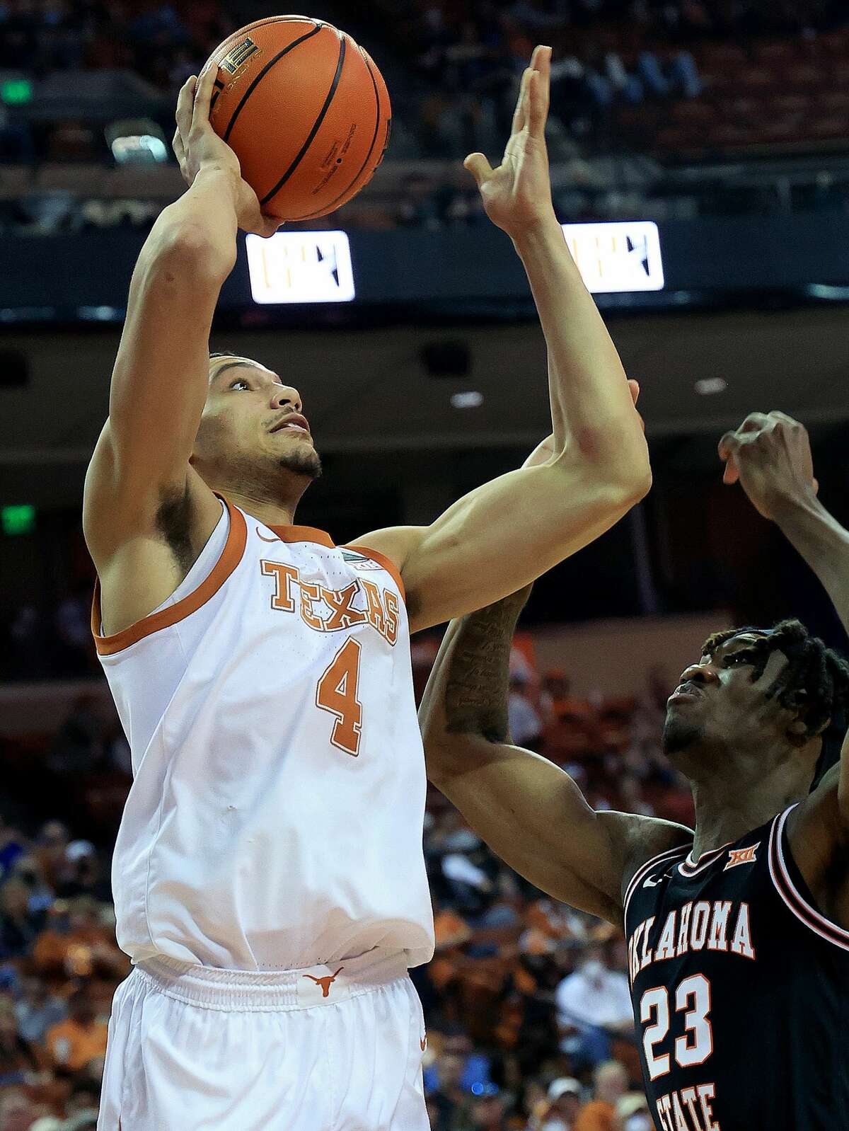 AUSTIN, TEXAS - JANUARY 22: Dylan Disu #4 of the Texas Longhorns shoots over Tyreek Smith #23 of the Oklahoma State Cowboys at The Frank Erwin Center on January 22, 2022 in Austin, Texas. (Photo by Chris Covatta/Getty Images)