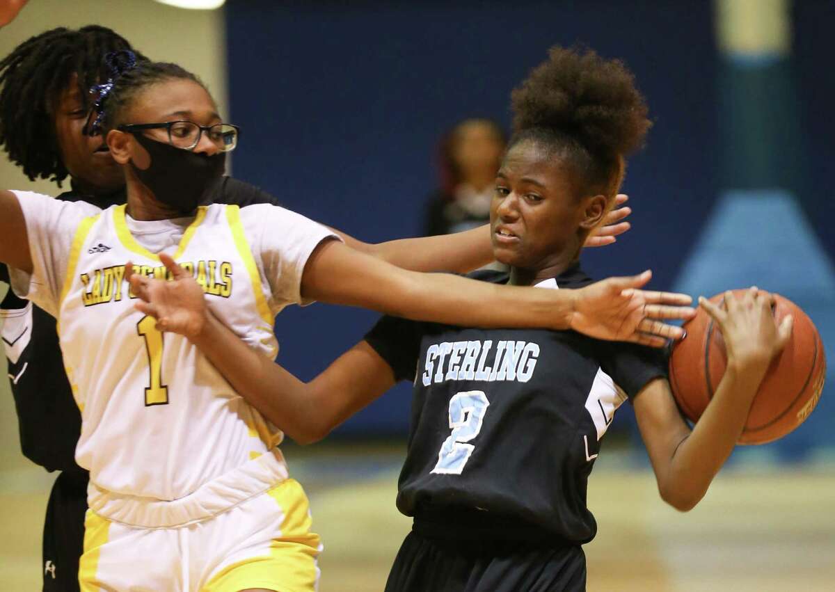 Sterling High School’s Destiny Lewis (2) tries to steal the ball from Wisdom High School’s Nishanti Wilson (1) in a District 23-5A game at Barnett Fieldhouse in Houston on Thursday, Jan. 20, 2022. Sterling won the game 65-23.