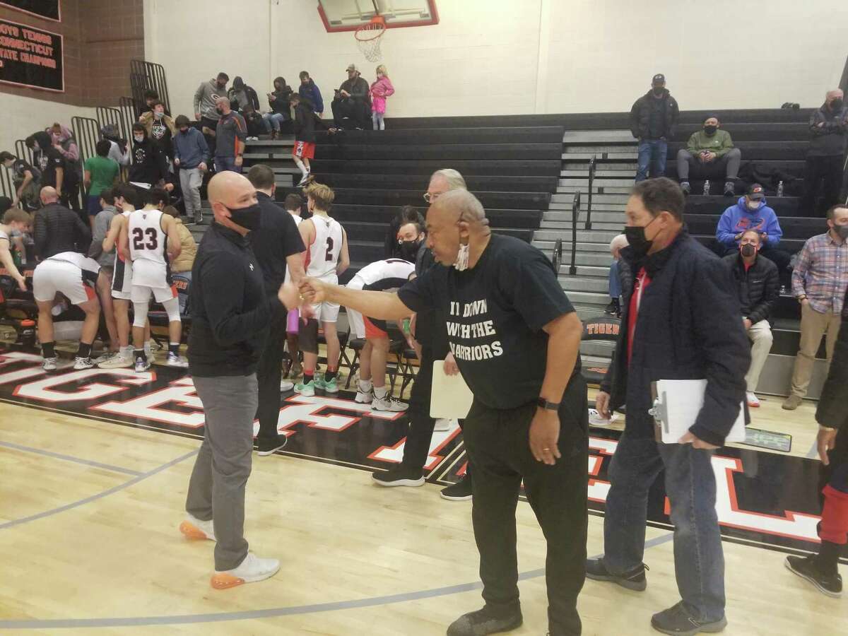 Ridgefield boys basketball coach Andrew McClellan, left, and Windsor coach Ken Smith exchange a fist bump following Windsor's 67-64 non-conference win at Ridgefield High on Saturday.
