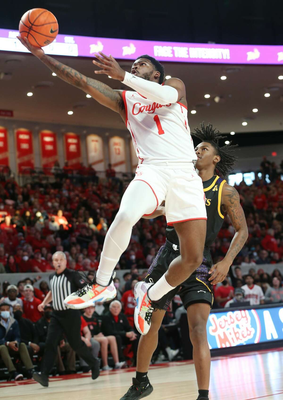 Houston Cougars guard Jamal Shead (1) drives to the basket around East Carolina Pirates guard Javon Small (1) in the first half at the Fertitta Center in Houston on Saturday, Jan. 22, 2022.