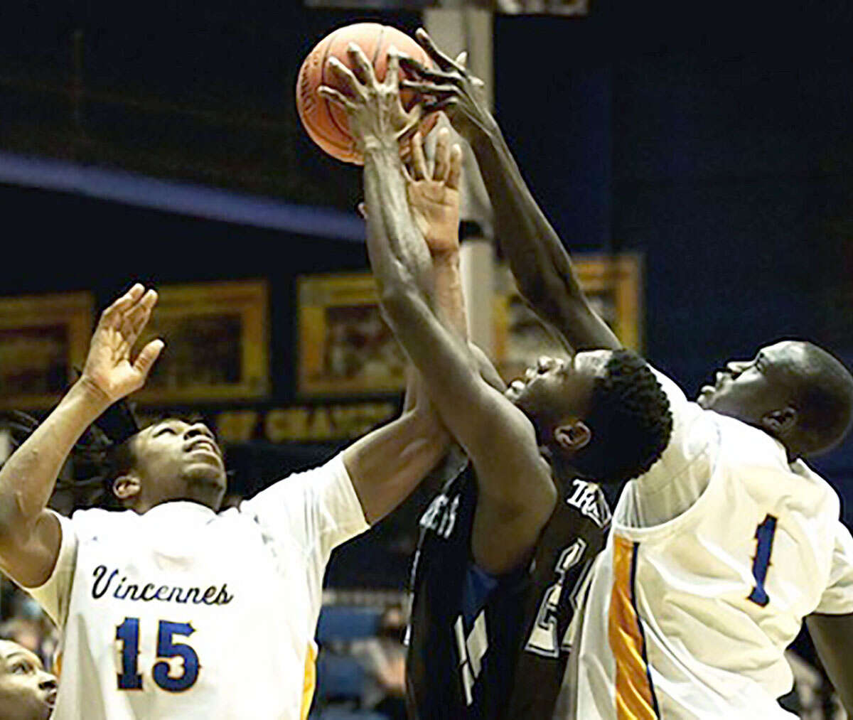 La'Terion White of Lewis and Clark, center, battles for a rebound with Vincennes' Darrius Davis (15) and Thow James Biehl Saturday night in Vincennes, Ind.