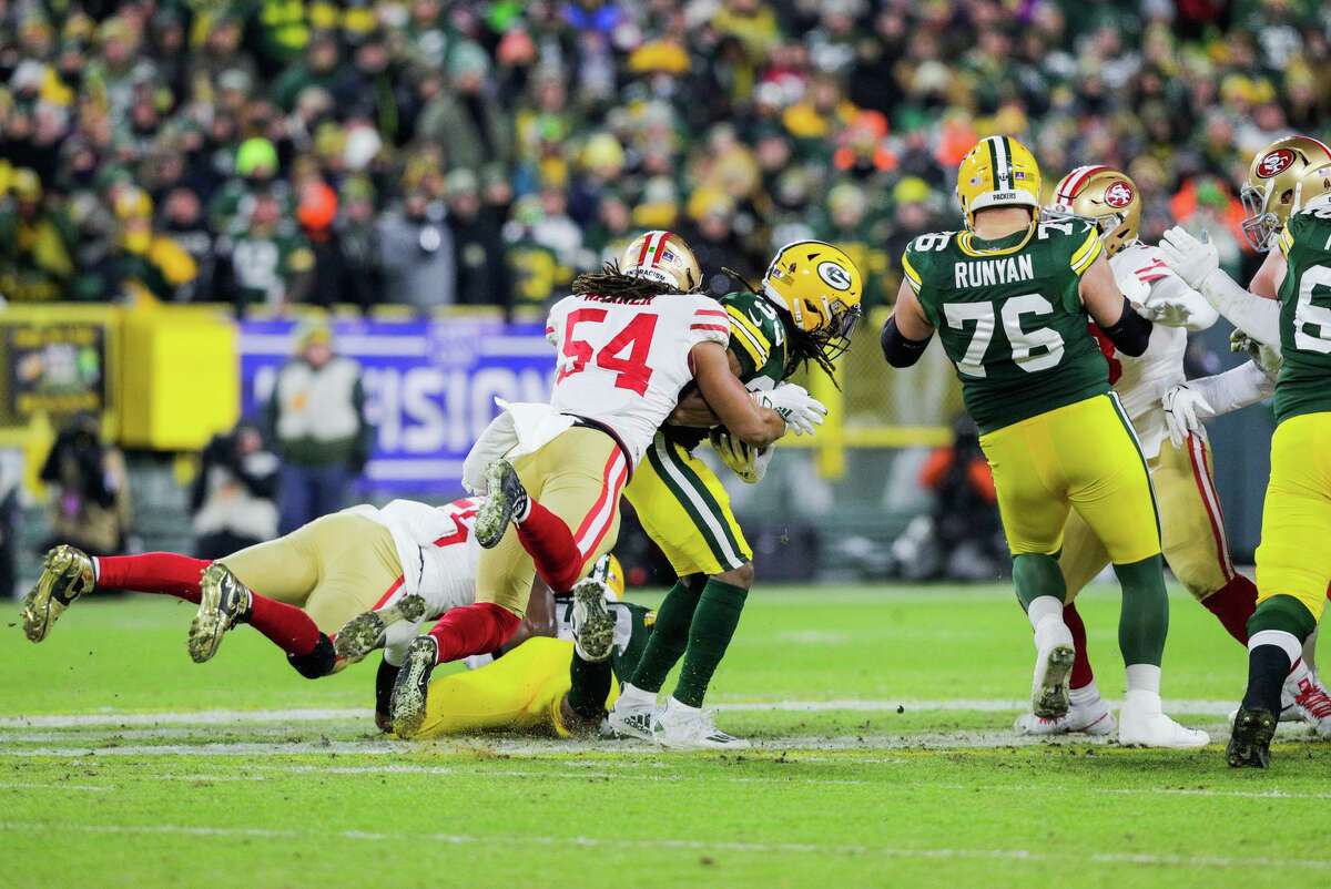 San Francisco 49ers middle linebacker Fred Warner (54) tackles Green Bay Packers running back Aaron Jones (33) as the San Francisco 49ers play the Green Bay Packers in the NFL Divisional Round playoff game at Lambeau Field in Green Bay, Wis., on Saturday, January 22, 2022.
